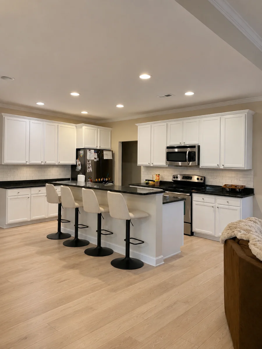 Remodeled kitchen with white cabinets and new flooring
